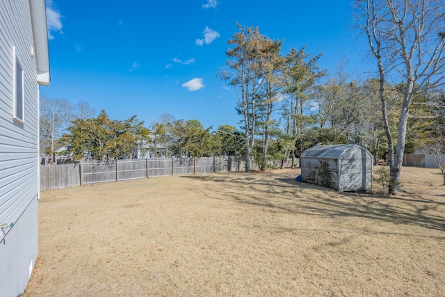 view of yard with a storage shed, a fenced backyard, and an outdoor structure