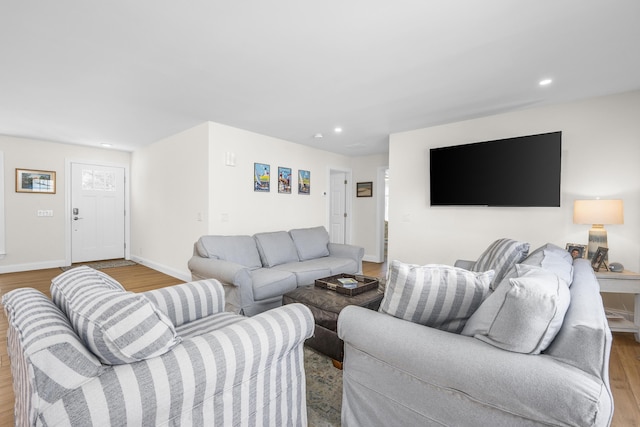 living area with recessed lighting, baseboards, and wood finished floors