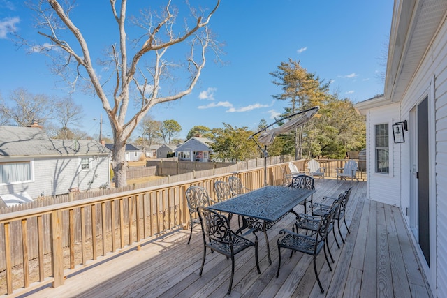 wooden deck featuring a residential view, outdoor dining space, and fence