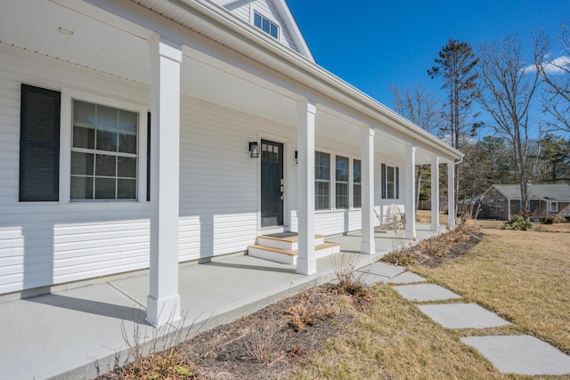 entrance to property with a lawn and a porch