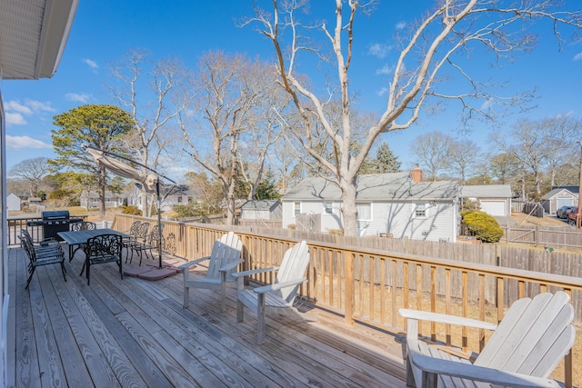 deck with outdoor dining area, fence, and a residential view