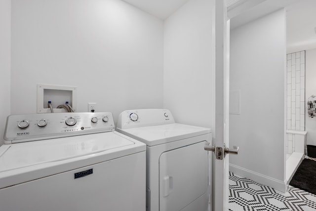 clothes washing area featuring laundry area, baseboards, and washer and clothes dryer