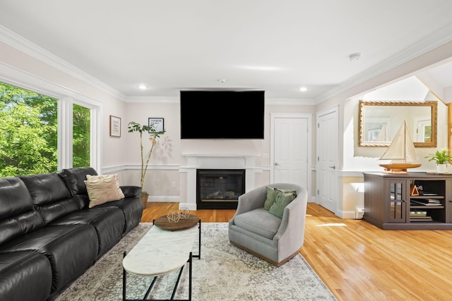 152 Algonquin Ave, Mashpee, MA 02649 - living area with light wood-type flooring, a glass covered fireplace, ornamental molding, recessed lighting, and a wainscoted wall
