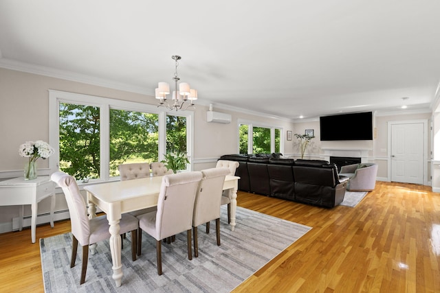 152 Algonquin Ave, Mashpee, MA 02649 - dining area featuring a chandelier, crown molding, baseboard heating, a wall mounted AC, and light wood-style floors