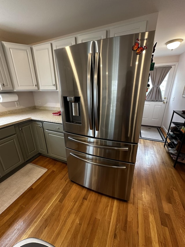 121 Camp St Unit 108, West Yarmouth, MA 02673 - kitchen with stainless steel fridge with ice dispenser, wood finished floors, white cabinetry, and gray cabinetry