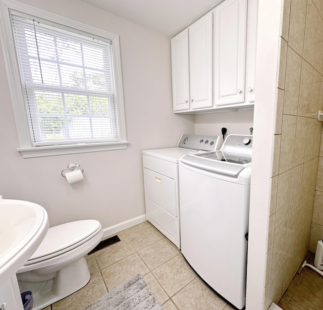 121 Camp St Unit 108, West Yarmouth, MA 02673 - laundry area featuring washing machine and dryer, light tile patterned floors, and baseboards
