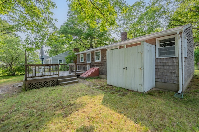 64 Uncle Percys Rd, Mashpee, MA 02649 - rear view of property with a chimney, a wooden deck, and a lawn