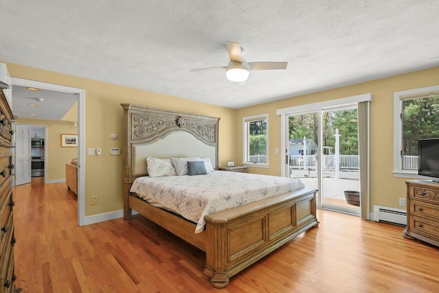 34 Marla Ln, Hatchville, MA 02536 - bedroom featuring baseboard heating, access to outside, light wood-style floors, multiple windows, and a textured ceiling