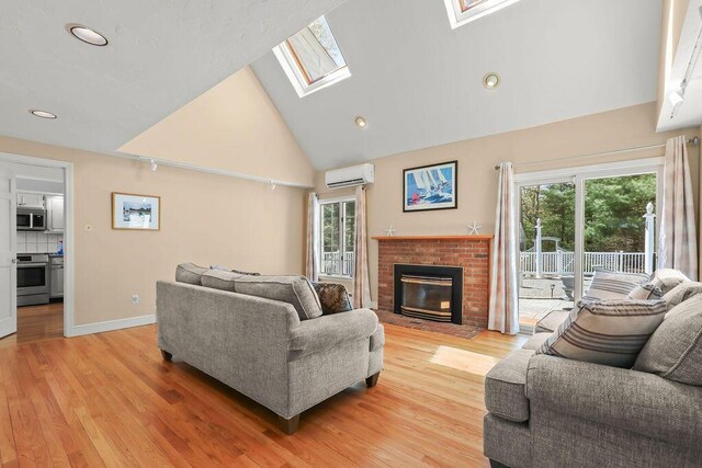34 Marla Ln, Hatchville, MA 02536 - living room with a wall mounted air conditioner, healthy amount of natural light, a skylight, high vaulted ceiling, and a brick fireplace
