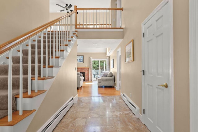 34 Marla Ln, Hatchville, MA 02536 - foyer with a baseboard heating unit, stairs, a ceiling fan, and a high ceiling