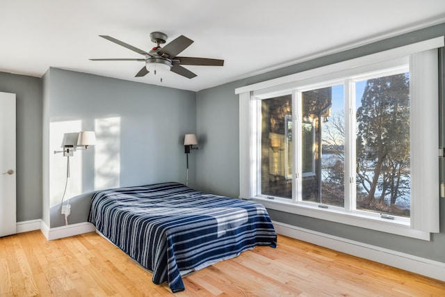 bedroom with wood finished floors, a ceiling fan, and baseboards