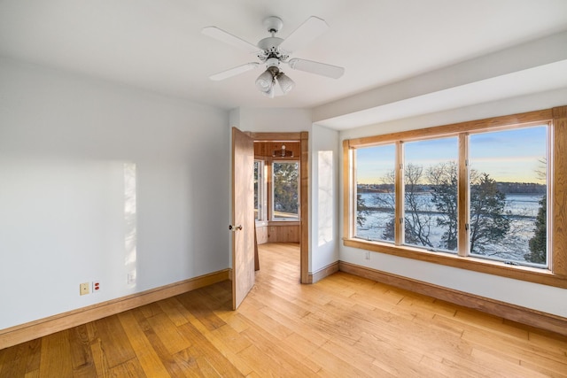 unfurnished bedroom with light wood-type flooring, ceiling fan, and baseboards