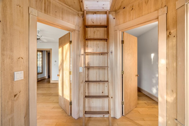 hallway with light wood finished floors and baseboards