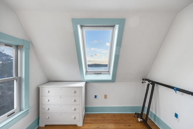 bonus room with light wood-style flooring, baseboards, and vaulted ceiling