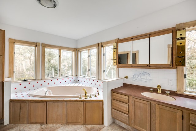 bathroom with vanity, plenty of natural light, backsplash, and a bath