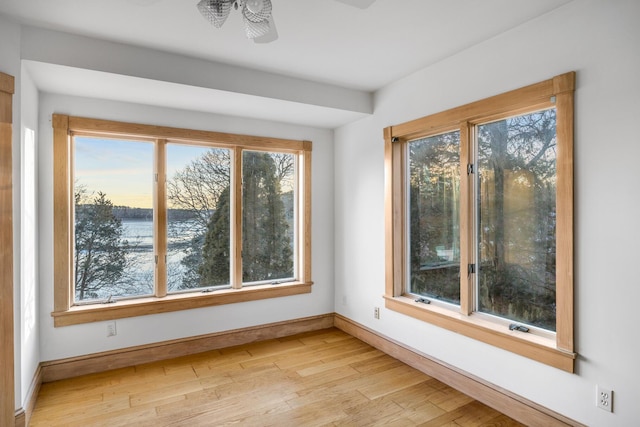 unfurnished sunroom featuring ceiling fan and plenty of natural light