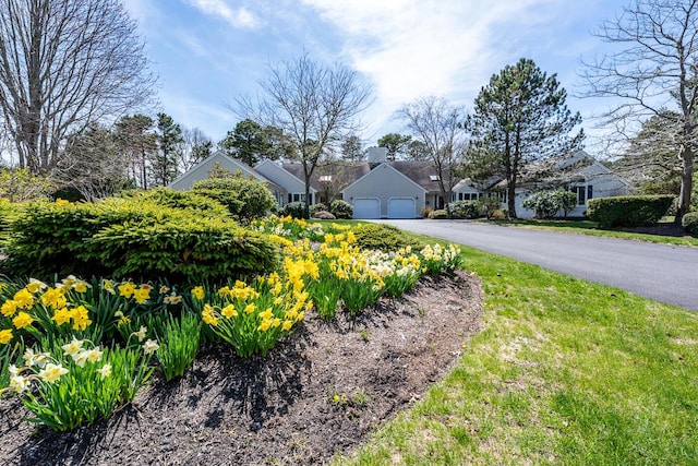 exterior space with an attached garage, a residential view, and aphalt driveway