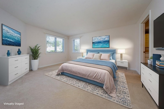 bedroom with light colored carpet and baseboards