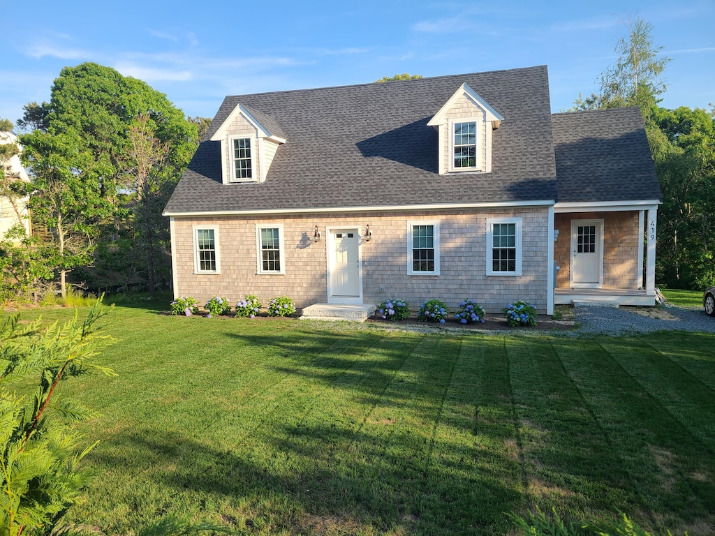 cape cod-style house featuring a front yard