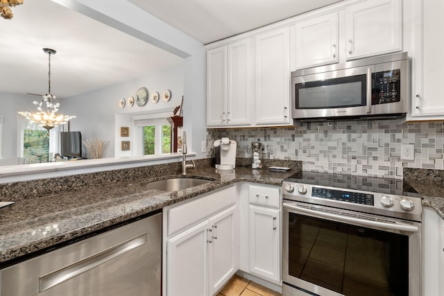 kitchen featuring sink, dark stone countertops, white cabinets, and appliances with stainless steel finishes