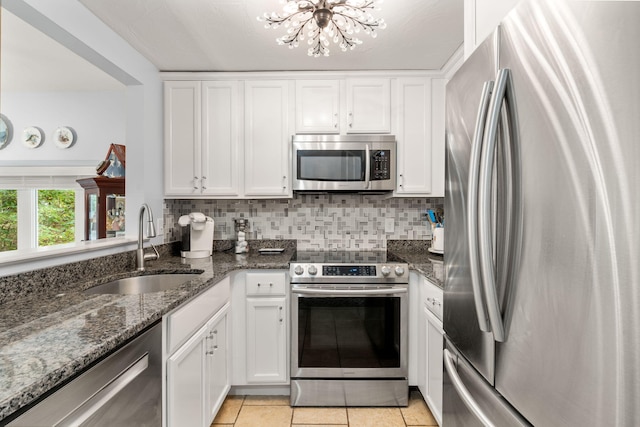 kitchen with sink, white cabinets, light tile patterned floors, and appliances with stainless steel finishes