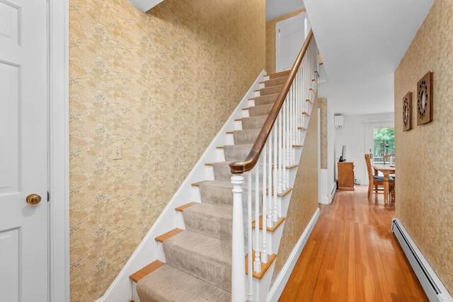 105 Rolling Hitch Rd, Centerville, MA 02632 - stairs with baseboards, wallpapered walls, wood finished floors, and baseboard heating