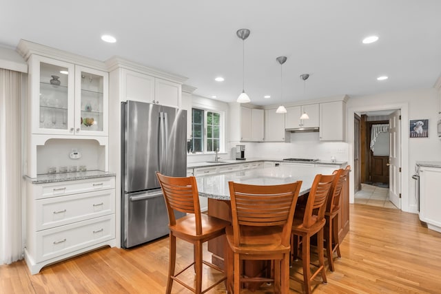 105 Rolling Hitch Rd, Centerville, MA 02632 - kitchen with glass insert cabinets, light wood-type flooring, freestanding refrigerator, white cabinetry, and a kitchen island