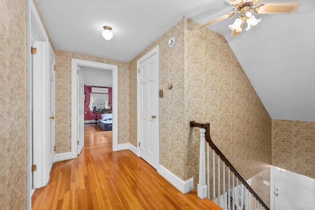 105 Rolling Hitch Rd, Centerville, MA 02632 - hallway featuring wallpapered walls, vaulted ceiling, an upstairs landing, baseboards, and light wood-style flooring