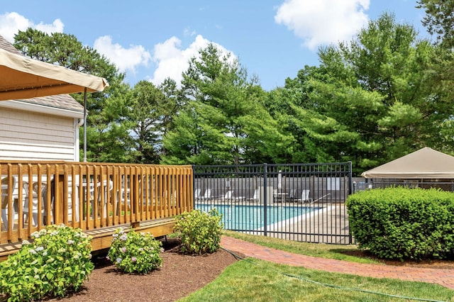 pool featuring fence and a wooden deck