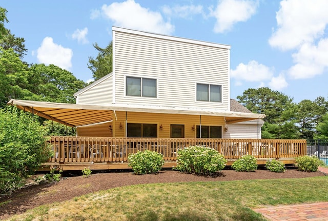 back of property with a wooden deck and a yard