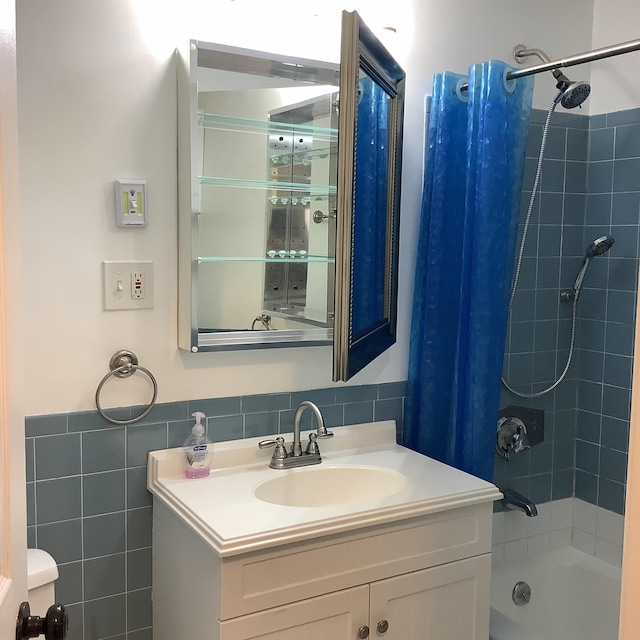 bathroom featuring shower / bath combo, tile walls, and vanity