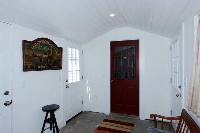 foyer featuring unfinished concrete floors, vaulted ceiling, and recessed lighting