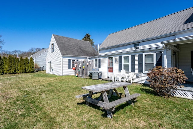 back of property with central AC and a yard