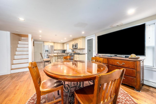 dining space featuring stairway, a baseboard radiator, light wood-style floors, and recessed lighting