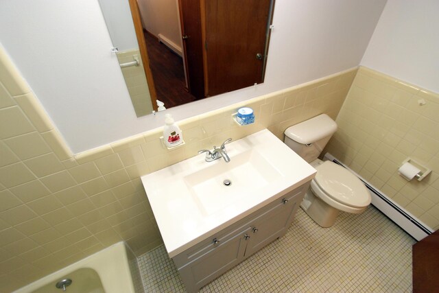 bathroom featuring baseboard heating, tile patterned flooring, vanity, tile walls, and toilet