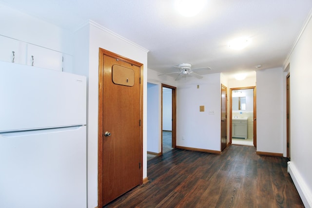 hallway with crown molding, baseboard heating, and dark wood-type flooring