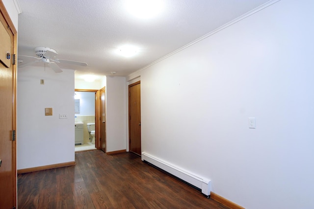 empty room with crown molding, ceiling fan, a baseboard heating unit, dark wood-type flooring, and a textured ceiling