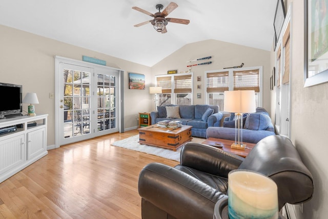 living area featuring lofted ceiling, baseboards, a ceiling fan, and light wood-style floors