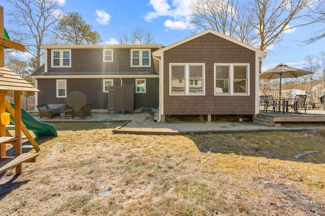 back of property with a playground and a patio