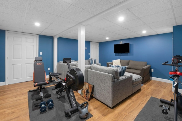 exercise area featuring recessed lighting, wood finished floors, a paneled ceiling, and baseboards