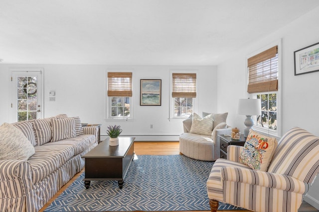 living room featuring a baseboard heating unit and wood finished floors