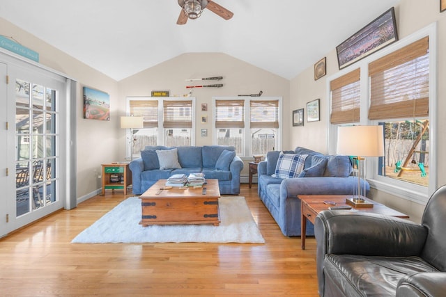 living area featuring light wood-type flooring, baseboards, a ceiling fan, and lofted ceiling