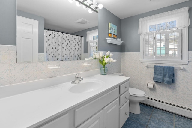 full bath featuring plenty of natural light, a baseboard radiator, vanity, and tile patterned floors