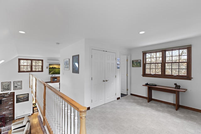 entrance foyer featuring recessed lighting, an AC wall unit, baseboards, and light carpet