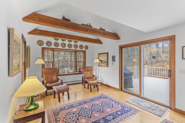 sitting room featuring baseboard heating, light wood-style flooring, lofted ceiling with beams, and baseboards