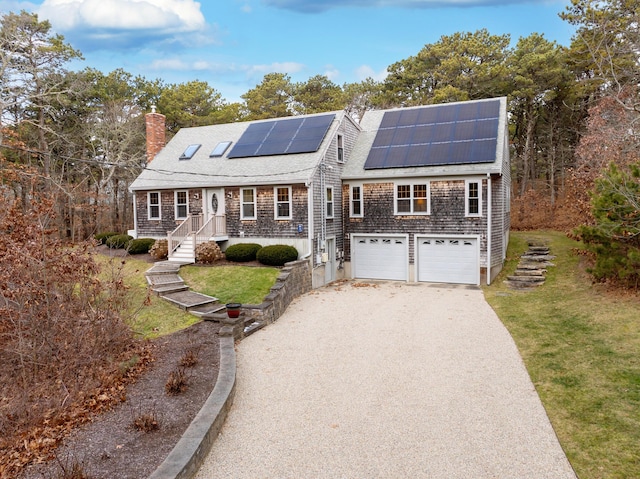 shingle-style home featuring solar panels, driveway, a chimney, and a front yard