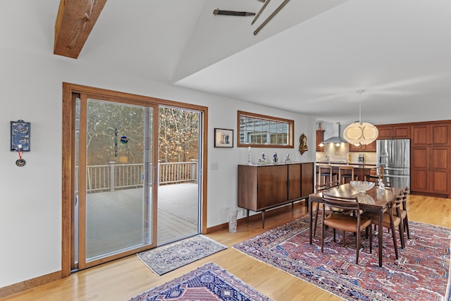 dining room featuring baseboards and light wood finished floors