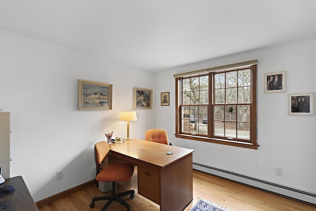 office featuring baseboard heating, baseboards, and wood finished floors