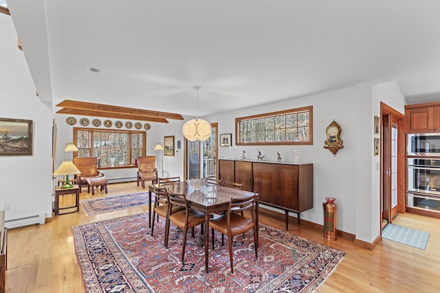 dining space with light wood-type flooring, baseboards, and baseboard heating