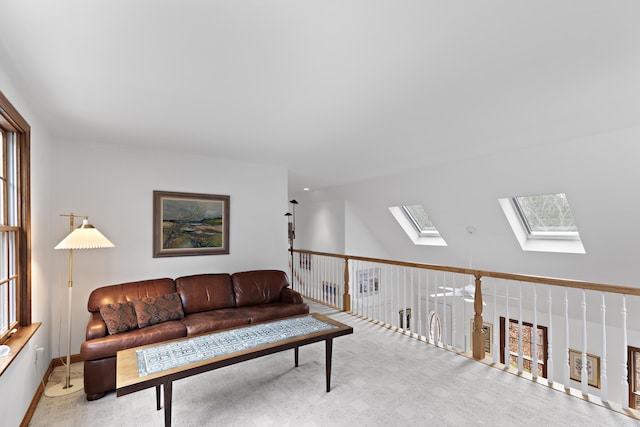 living room with carpet floors and vaulted ceiling with skylight